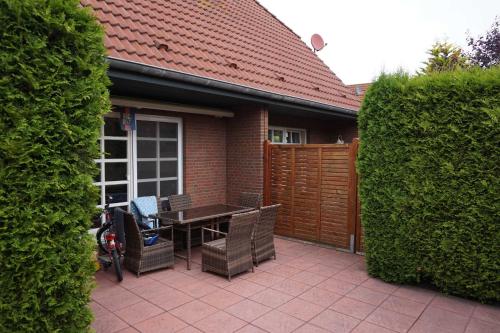 カロリーネンジールにあるFerienhaus Tovarのパティオ(テーブル、椅子、フェンス付)