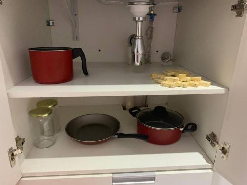 a kitchen with two pots and pans on a shelf at Studio na Bela Vista in Sao Paulo