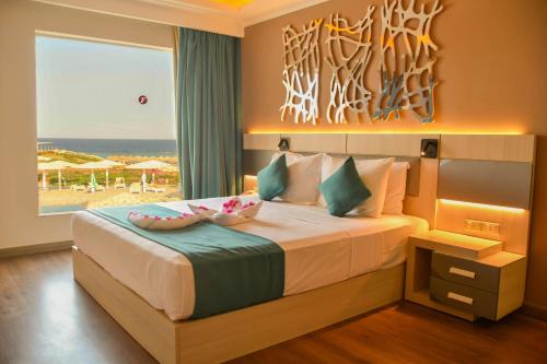 a bedroom with a bed with a view of the beach at SIRENA BEACH RESORT & SPA in Marsa Alam City