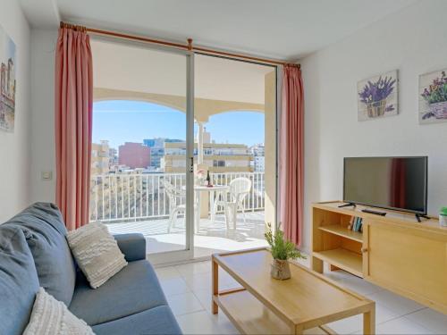 a living room with a blue couch and a tv at Apartment Apolo VII-7 by Interhome in Calpe