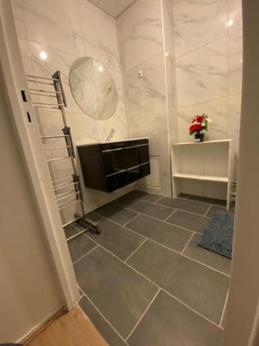uma casa de banho com televisão e piso em azulejo em T2 entier Chambre+Salon+Cuisine em Les Ulis