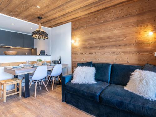 un salon avec un canapé bleu et une cuisine dans l'établissement Apartment Le Curling A - Val Claret-23 by Interhome, à Tignes