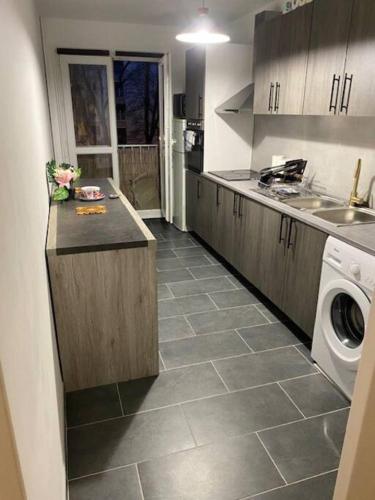 a kitchen with a sink and a washing machine at T2 entier Chambre+Salon+Cuisine in Les Ulis