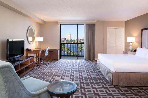 Cette chambre comprend un lit, un bureau et une télévision. dans l'établissement DoubleTree by Hilton Jacksonville Riverfront, FL, à Jacksonville