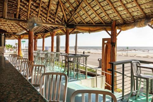 a row of tables and chairs at the beach at DoubleTree by Hilton Galveston Beach in Galveston