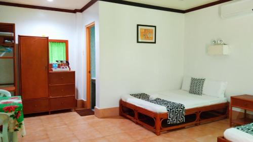 a room with a small bed in the corner of a room at HMC Guesthouse - Malapascua Island Air-conditioned Room #2 in Logon