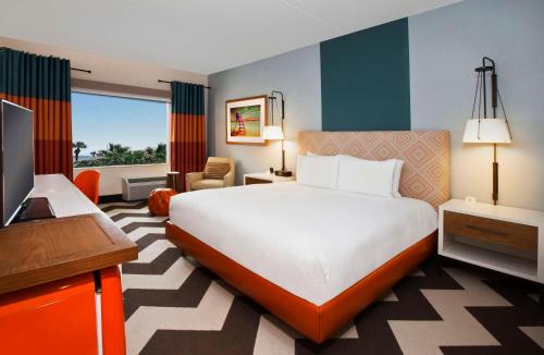 a hotel room with a large bed and a desk at DoubleTree by Hilton Galveston Beach in Galveston