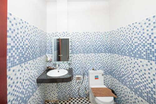a blue tiled bathroom with a sink and a toilet at Damnak Soksan Hotel in Siem Reap