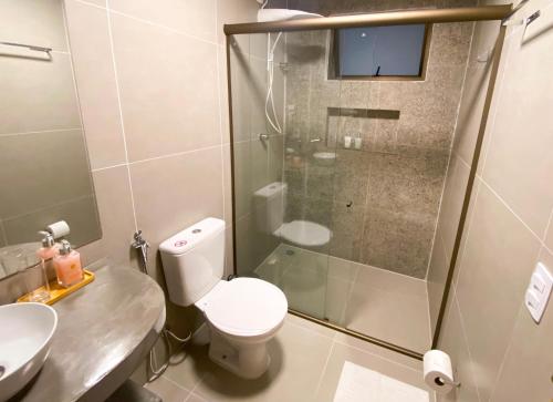 a bathroom with a shower and a toilet and a sink at Pousada Baobá in Jericoacoara