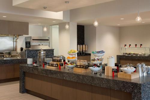 a kitchen with a counter with bowls of food on it at Embassy Suites by Hilton The Woodlands in The Woodlands