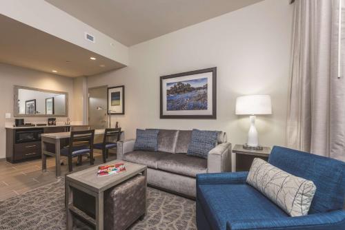 a living room with a couch and a dining room at Embassy Suites by Hilton The Woodlands in The Woodlands