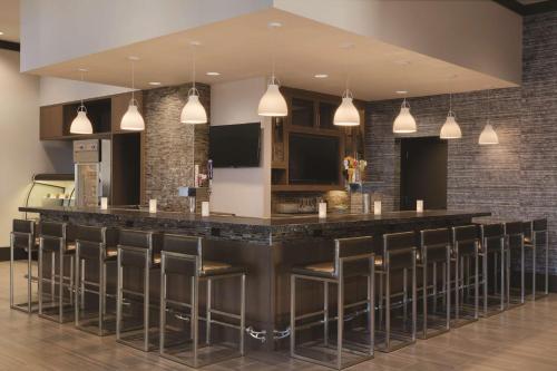 a bar in a restaurant with stools at Embassy Suites by Hilton The Woodlands in The Woodlands