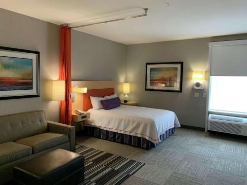 a hotel room with a bed and a couch at Home2 Suites by Hilton Fort Smith in Fort Smith