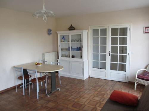 a kitchen with a table and chairs and a cabinet at Villa proche plage et centre - V06205 in Soulac-sur-Mer