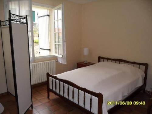 a bedroom with a large bed and a window at Villa proche plage et centre - V06205 in Soulac-sur-Mer