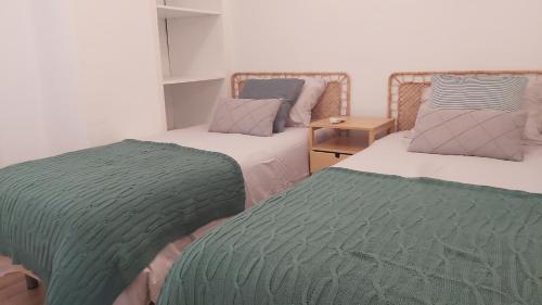 1 dormitorio con 2 camas y mantas verdes y grises en Del Parque Flats Alemania Soho, en Málaga