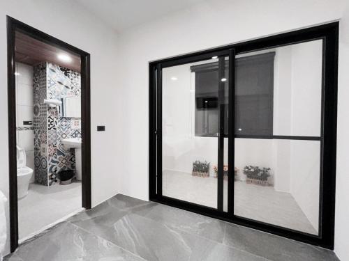 Xianqing Yizhi Homestay في مدينة تايتونج: نافذة زجاجية كبيرة في غرفة مع حمام