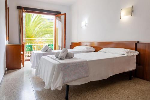 1 Schlafzimmer mit 2 Betten und weißer Bettwäsche in der Unterkunft Clipper Affiliated by FERGUS in Lloret de Mar