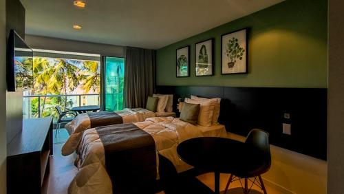 1 dormitorio con 2 camas, silla y ventana en RN Studio Premium, en Maceió