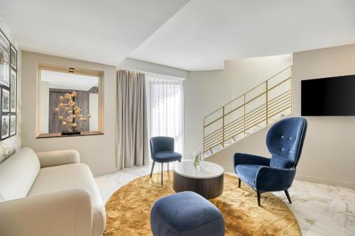 a living room with a white couch and blue chairs at Novotel Paris Centre Bercy in Paris