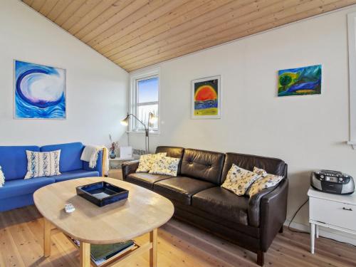 uma sala de estar com um sofá e uma mesa em Holiday Home Florida - 100m from the sea in NW Jutland by Interhome em Lokken