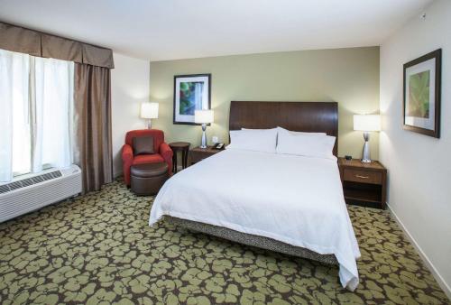 a hotel room with a bed and a chair at Hilton Garden Inn Jackson/Flowood in Flowood