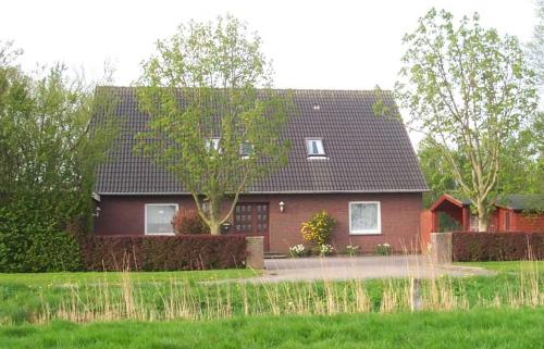 une maison rouge avec un toit noir dans l'établissement Ferienhof Mittag, à Altfunnixsiel