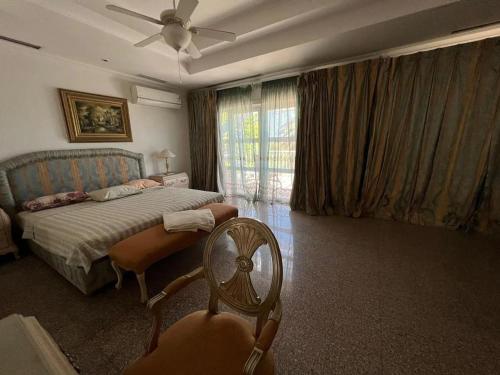 Schlafzimmer mit einem Bett, einem Ventilator und einem Stuhl in der Unterkunft Private villa in Sharm El Sheikh in Sharm El Sheikh