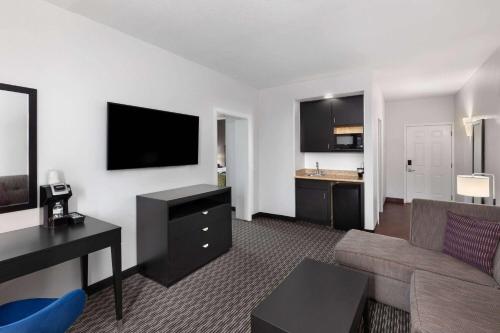 a living room with a couch and a flat screen tv at La Quinta by Wyndham Austin - Cedar Park in Cedar Park