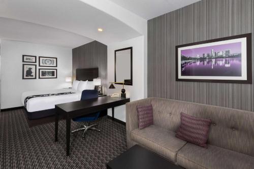 a hotel room with a bed and a couch and a desk at La Quinta by Wyndham Austin - Cedar Park in Cedar Park