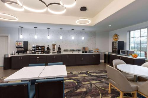 a large room with a kitchen with tables and chairs at La Quinta by Wyndham Austin - Cedar Park in Cedar Park