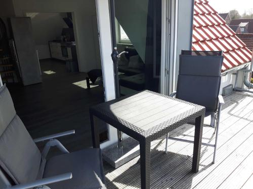 - une table et deux chaises sur une terrasse couverte dans l'établissement Ferienwohnung Claudia, à Carolinensiel