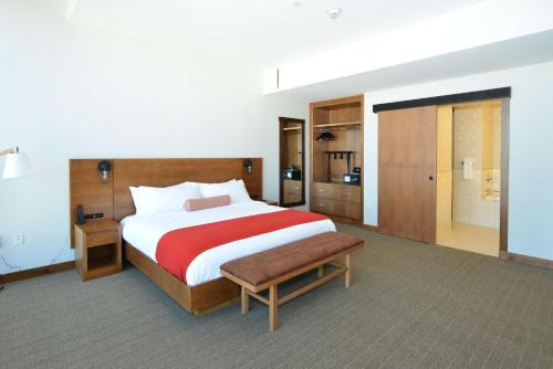 a bedroom with a large bed with a red and white blanket at The Lismore Hotel Eau Claire - a DoubleTree by Hilton in Eau Claire