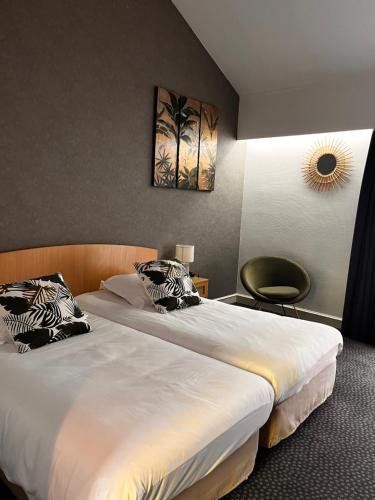 een hotelkamer met 2 bedden en een stoel bij Logis Le Relais Fleuri in Sauvigny-le-Bois