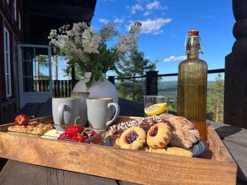 a tray of pastries on a table with a bottle of wine at Alpstigen 6B - 6 bäddars fjällstuga mitt i Järvsöbacken in Järvsö