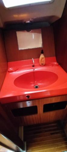 Precioso Barco en Barcelona في برشلونة: حمام مع حوض احمر في قارب