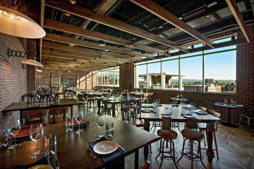 a restaurant with tables and chairs and large windows at Embassy Suites by Hilton Greenville Downtown Riverplace in Greenville