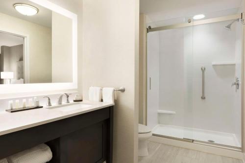 a bathroom with a sink and a shower at Embassy Suites by Hilton Greenville Downtown Riverplace in Greenville