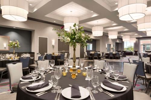 a large banquet room with a table with glasses and flowers at Embassy Suites by Hilton Greenville Downtown Riverplace in Greenville