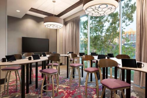 a conference room with a table and chairs and a tv at Embassy Suites by Hilton Greenville Downtown Riverplace in Greenville