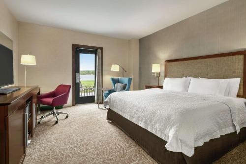 a hotel room with a bed and a desk and chairs at Hampton Inn Penn Yan, NY in Penn Yan