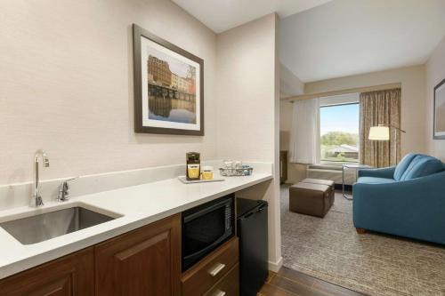 a kitchen with a sink and a living room at Hampton Inn Penn Yan, NY in Penn Yan