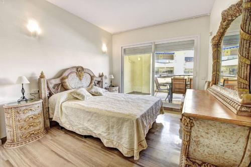 ベナルマデナにあるPuerto Marina Apartamento Exclusivo Benalmádenaのベッドルーム1室(ベッド1台、テーブル、窓付)