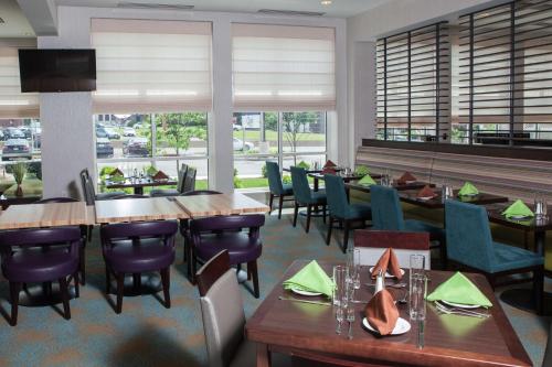 a restaurant with wooden tables and chairs and windows at Hilton Garden Inn Springfield in Springfield