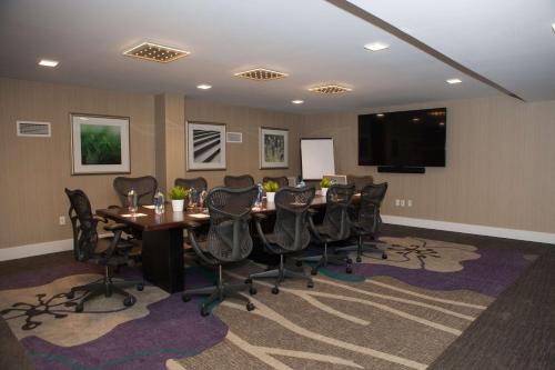 a conference room with a table and chairs and a flat screen tv at Hilton Garden Inn Springfield in Springfield