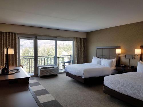 布恩的住宿－北卡州布恩漢普頓酒店及套房，酒店客房设有两张床和一个阳台。