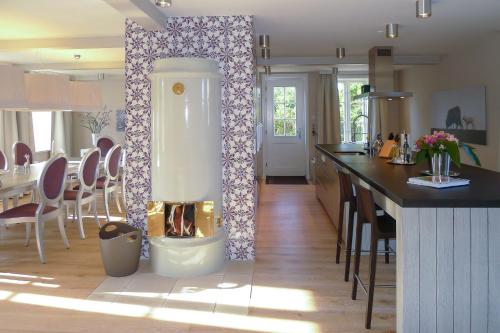 uma cozinha com lareira no meio de uma sala em Rungholt em Oevenum