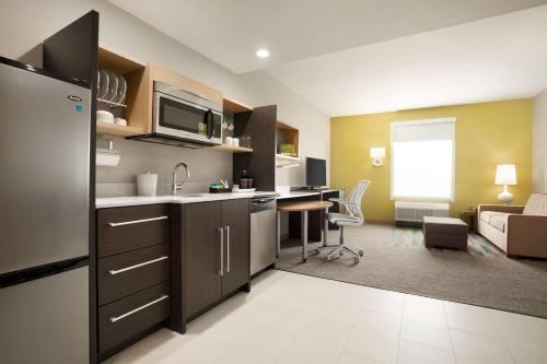 a kitchen and a living room with a couch at Home2 Suites by Hilton Houston Webster in Webster