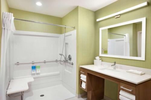 ein Bad mit einer Dusche, einem Waschbecken und einem Spiegel in der Unterkunft Home2 Suites by Hilton Houston Webster in Webster