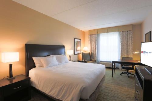 a hotel room with a large bed and a desk at Hilton Garden Inn Indiana at IUP in Indiana